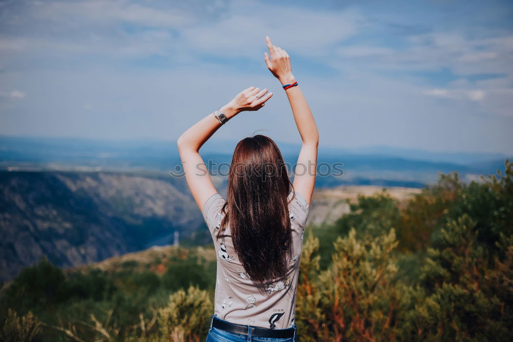 Similar – Woman looking out through a bridge, with a hand floating in the air.