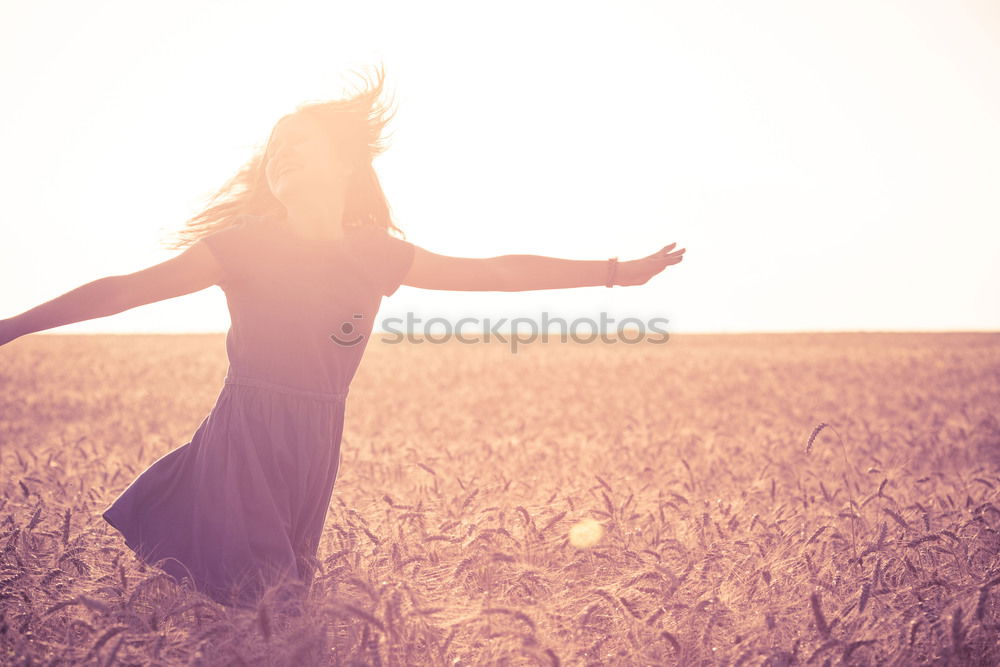 Young woman enjoying the sunset with wind blowing her hair