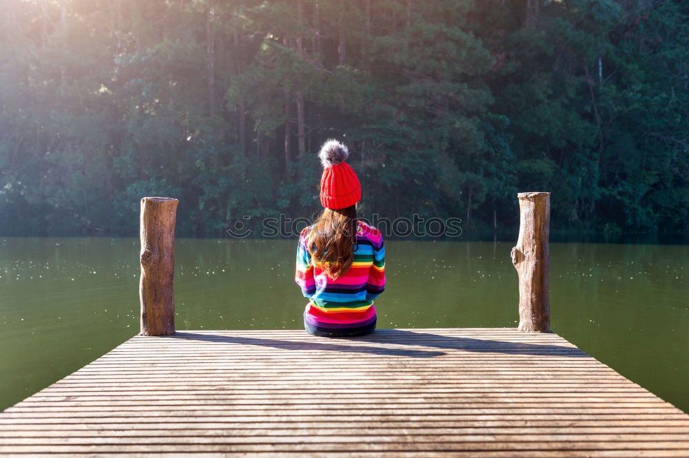 Similar – Foto Bild junge barfüßige, verträumte Frau mit Rock und Strohhut sitzt lasziv auf einem Holzsteg am See