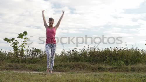 Similar – Agile young woman doing a handstand outdoors in the countryside balancing on her hands with her legs bent in opposite directions