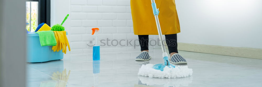 Similar – A househusband in pink slippers and cleaning utensils