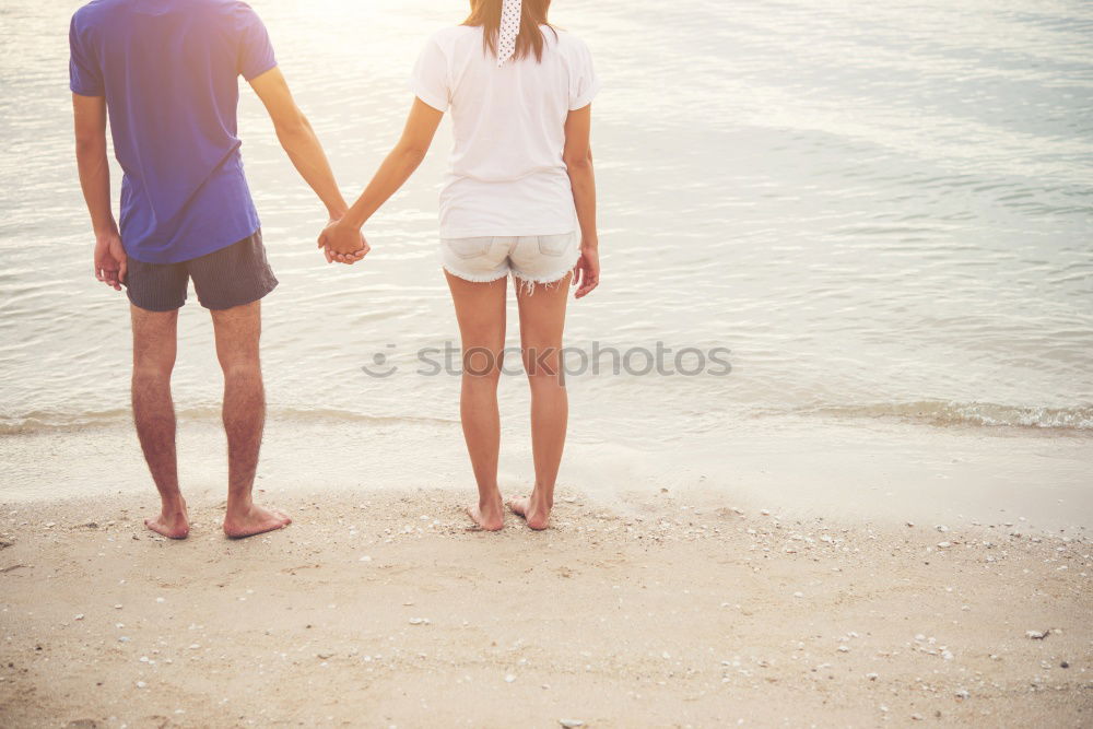 Two little kids holding her hands on a summer day