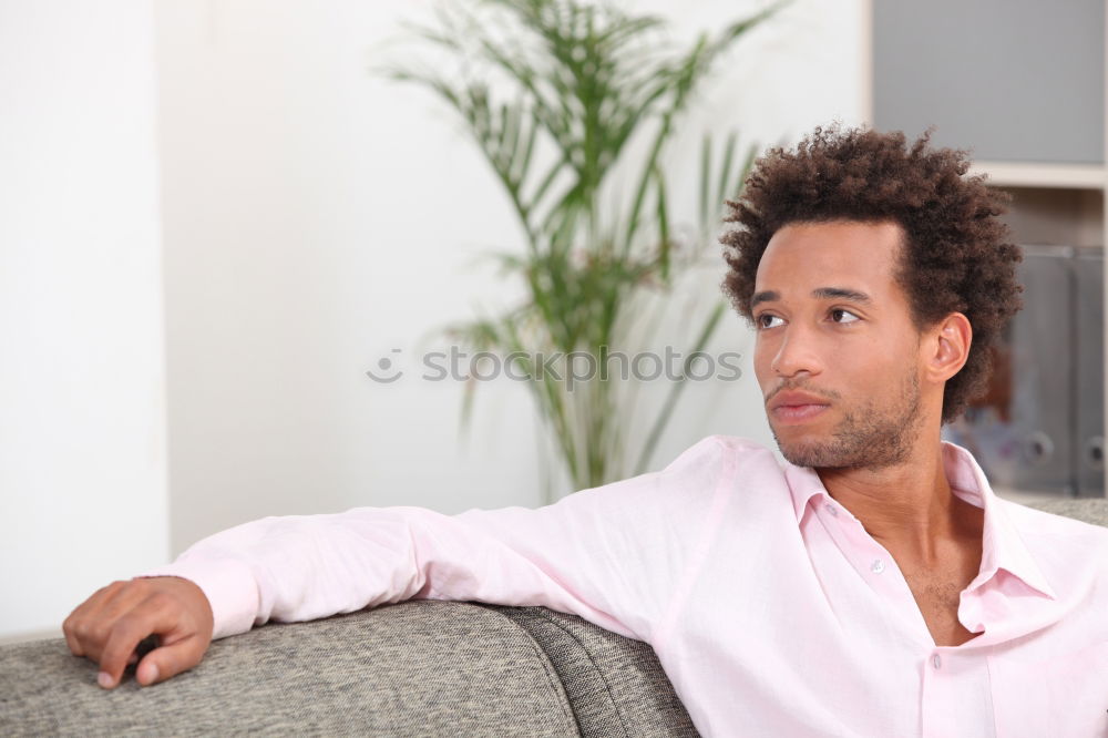 Similar – Portrait of a young thoughtful mixed race man sitting in the sofa