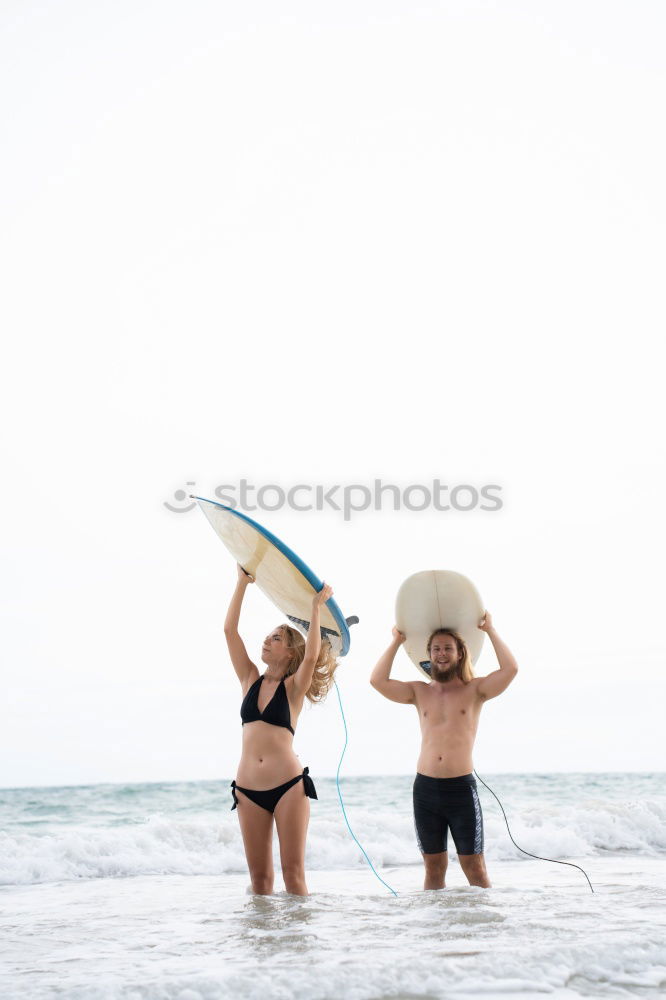 Similar – Aerial view of a surfing couple laying on the beach