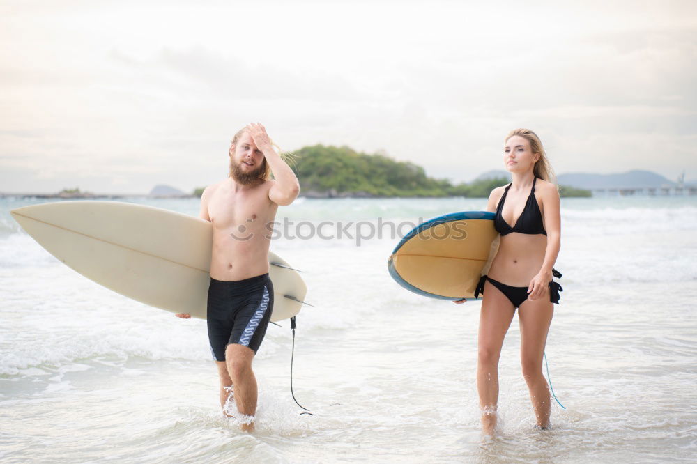 Similar – Aerial view of a surfing couple laying on the beach