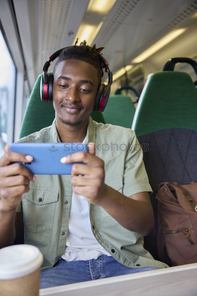 Similar – Image, Stock Photo Young man waiting listening music and using mobile phone at the airport with a suitcase.