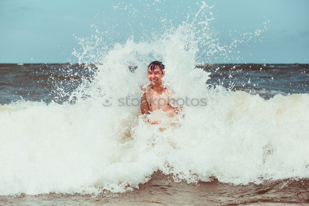 Young man enjoying the high waves in the sea