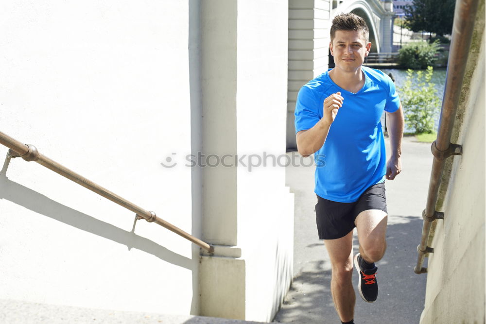 Image, Stock Photo Young man in sportswear leaning on metal fence and posing on sta