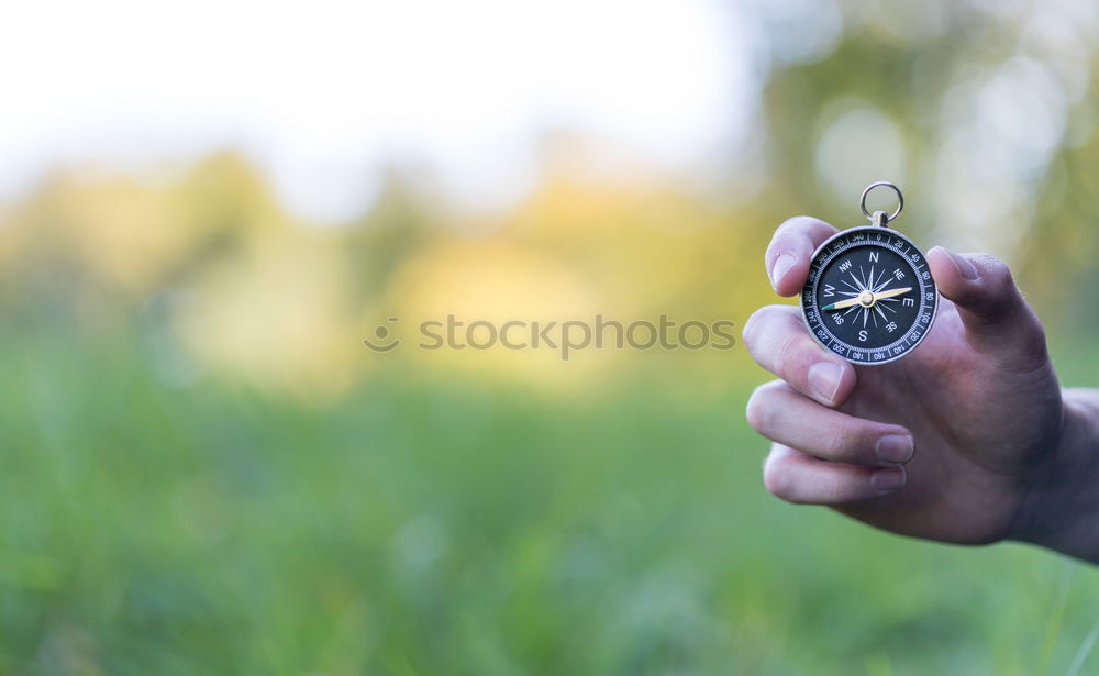 Similar – Image, Stock Photo Hand with compass at mountain road at blue sky