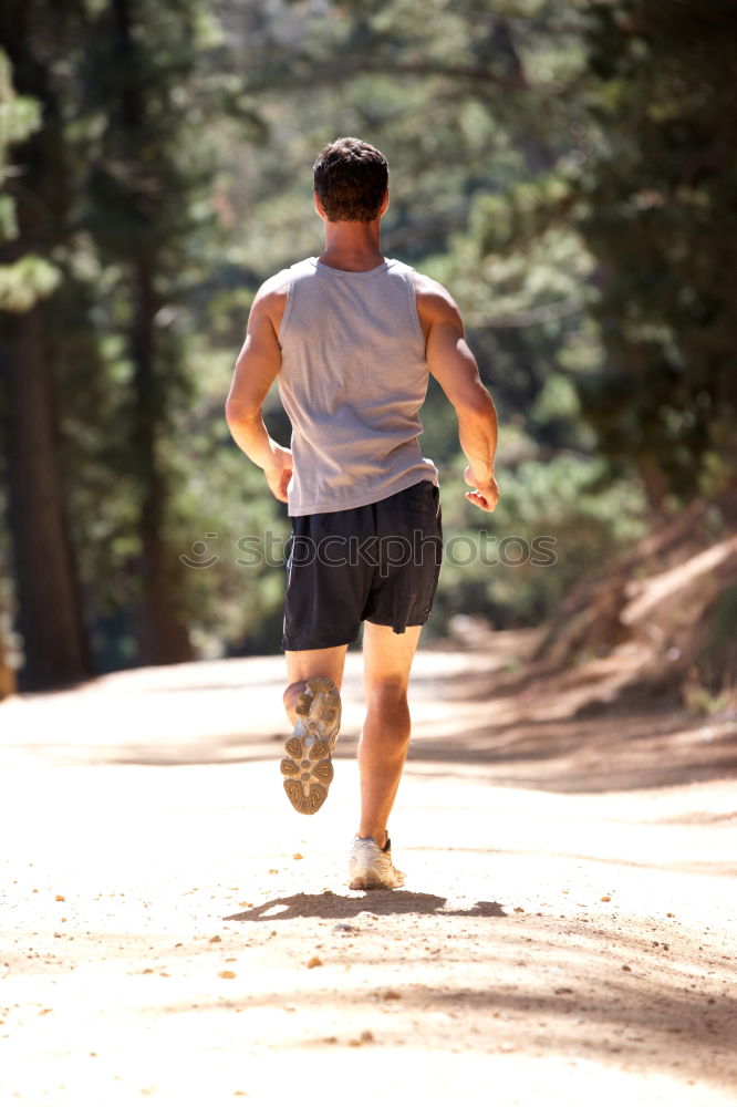 Image, Stock Photo Athletic young woman jogging along a forest track