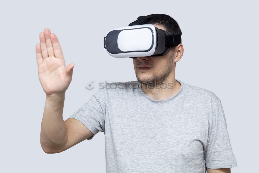 Similar – Mittlerer erwachsener Mann, der Virtual-Reality-Simulator Brille trägt, mit dem Finger zeigt und weißer Hintergrund