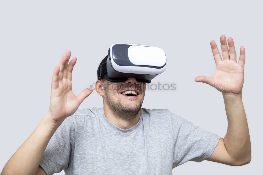 Similar – Man with VR glasses scared and raises hands on white background