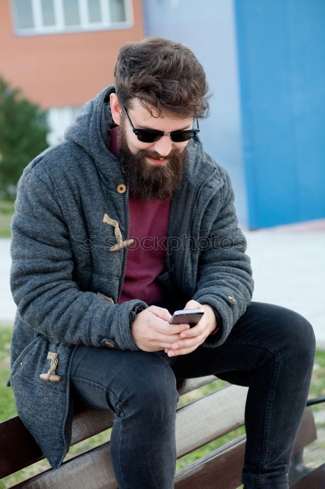 Image, Stock Photo Young smiling man looking at his smartphone in the street