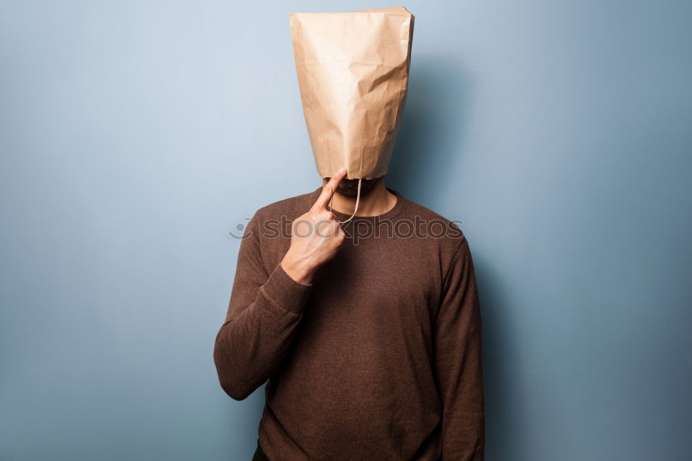 Similar – Person with paper bag on head pointing at camera