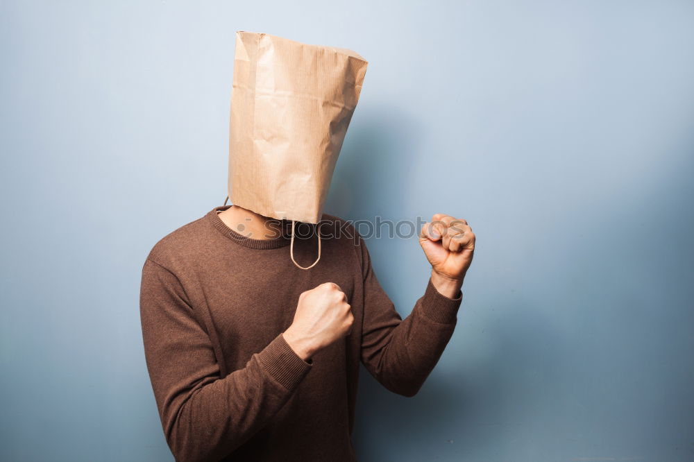 Similar – Person with paper bag on head pointing at camera