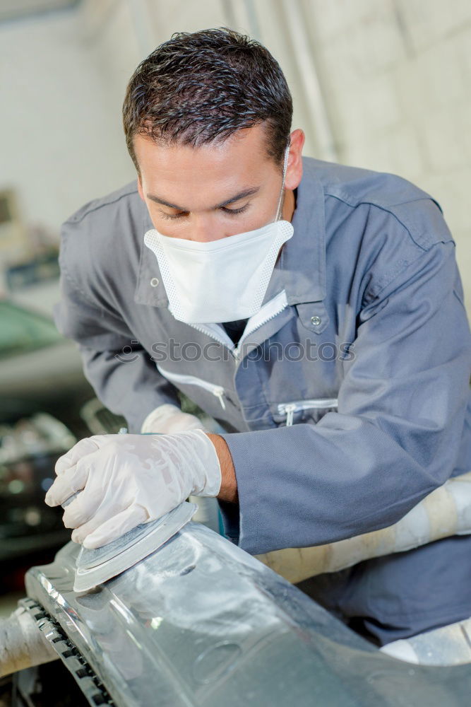 Similar – Man with a dust mask and goggles working on a circular saw