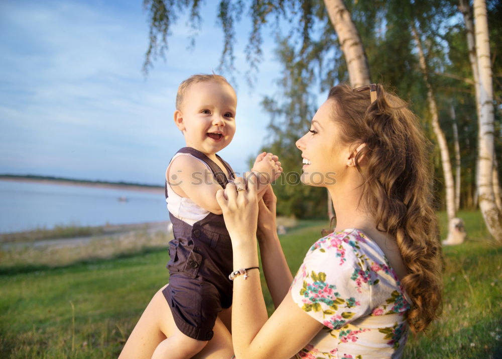 Mother holding kid on hands in park