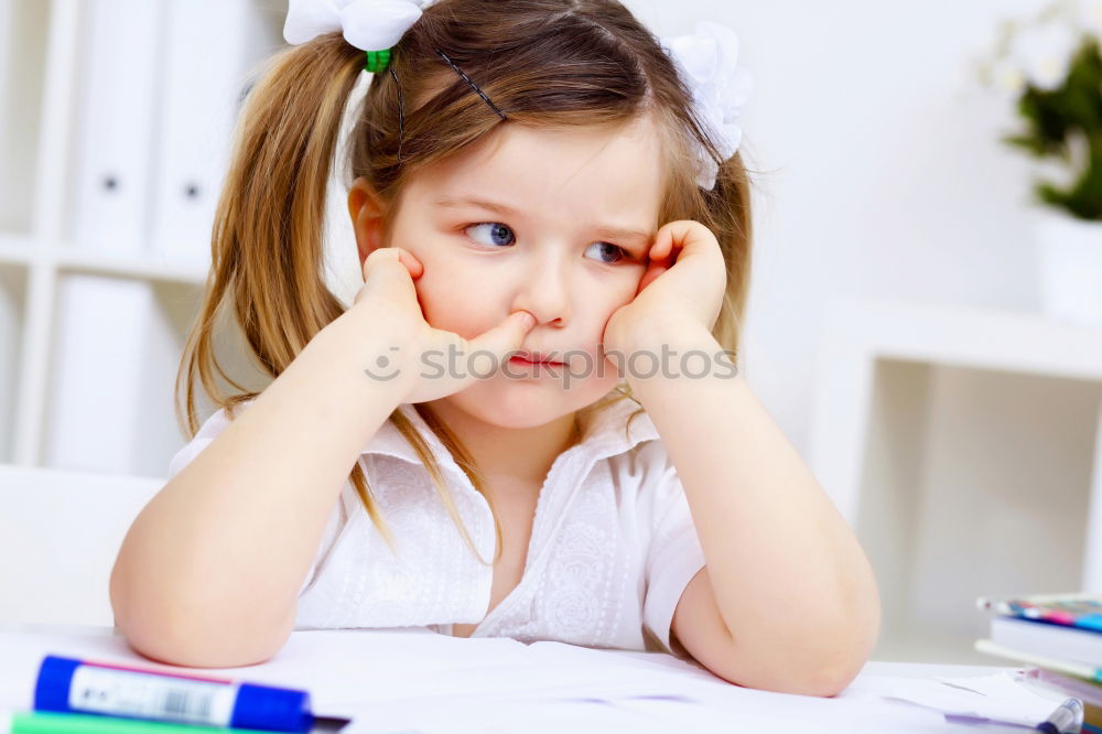 Similar – Thoughtful girl writing in class