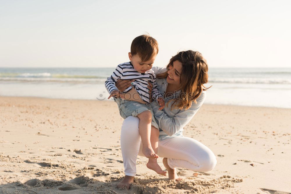 Similar – mother and son having fun with inflatable ring at beach