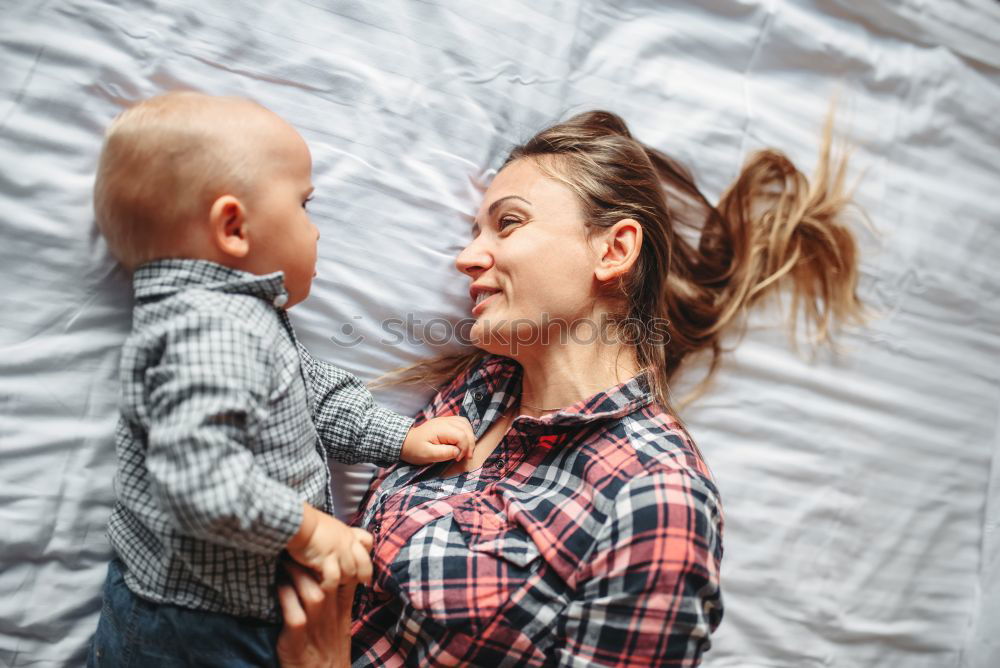 Similar – happy young mother and her baby boy lying on bed and smiling