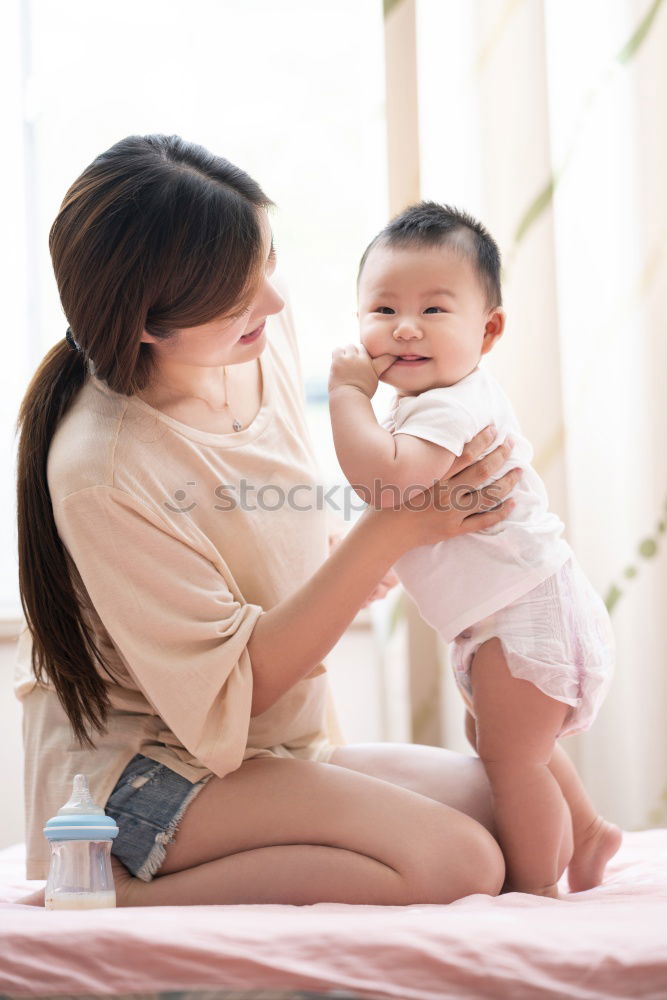 happy mother hugs her toddler son