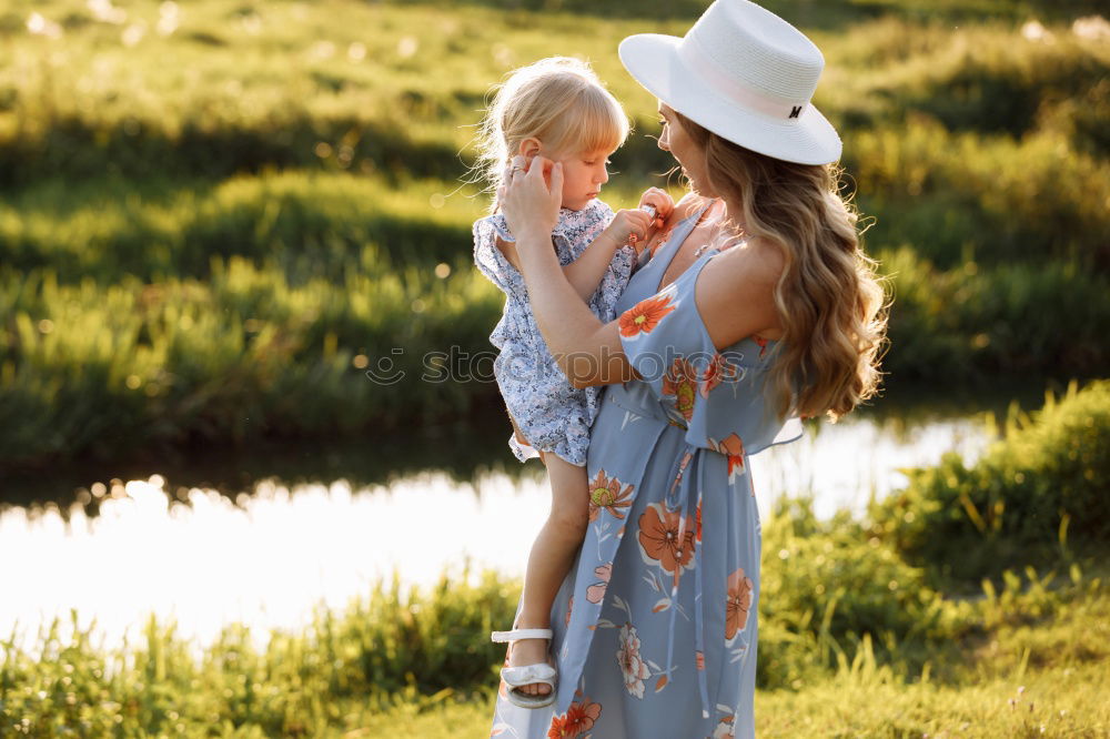 Similar – Mother holding kid on hands in park