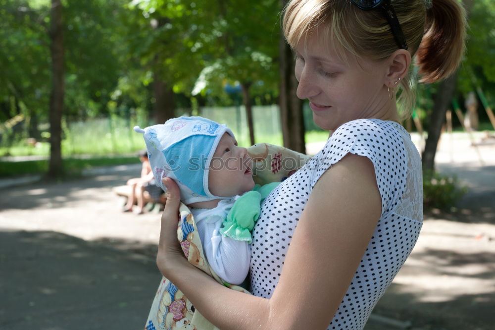 Similar – Mother holding kid on hands in park