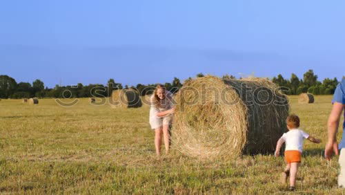 Similar – Brothers playing in the field.Children take pictures in the straw field