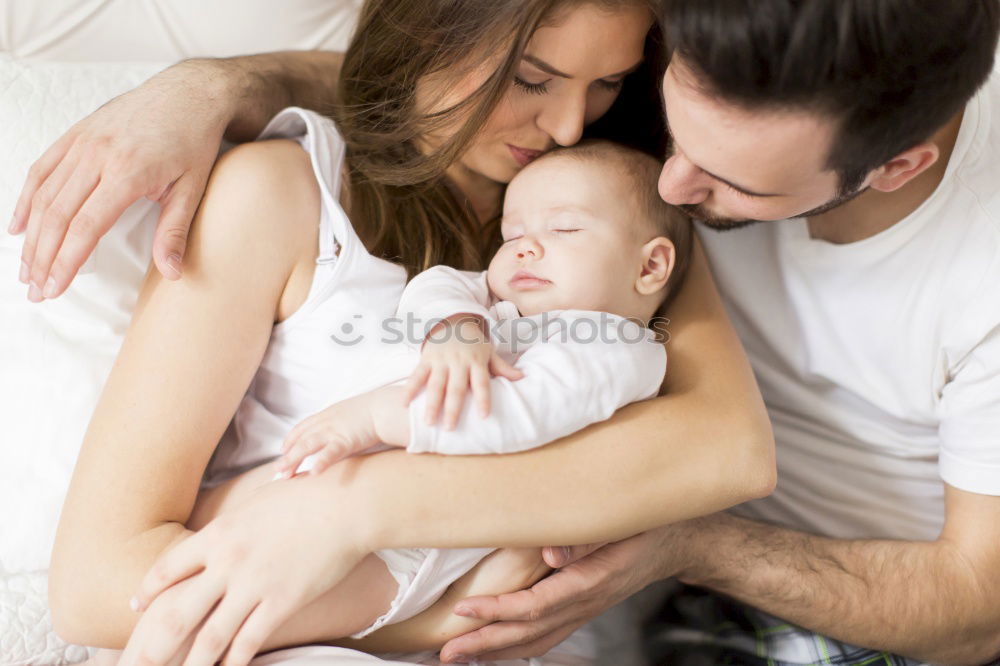 Similar – Image, Stock Photo Couple embracing a newborn over dark background