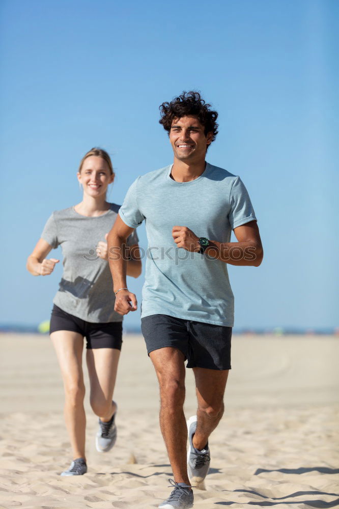 Similar – Image, Stock Photo Young couple running on a seafront promenade