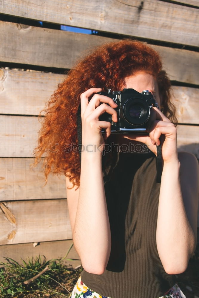 Young redhead photographer woman