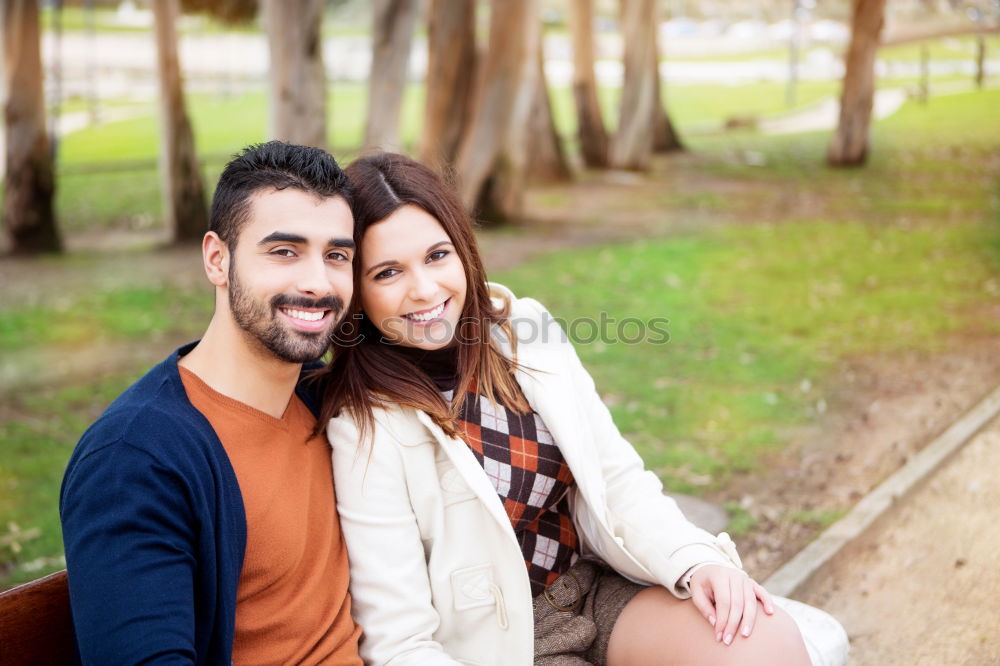 Beautiful young couple laying on grass in an urban park