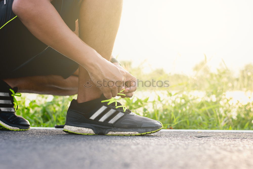 Similar – Runner get ready for run, tying sneakers shoelaces