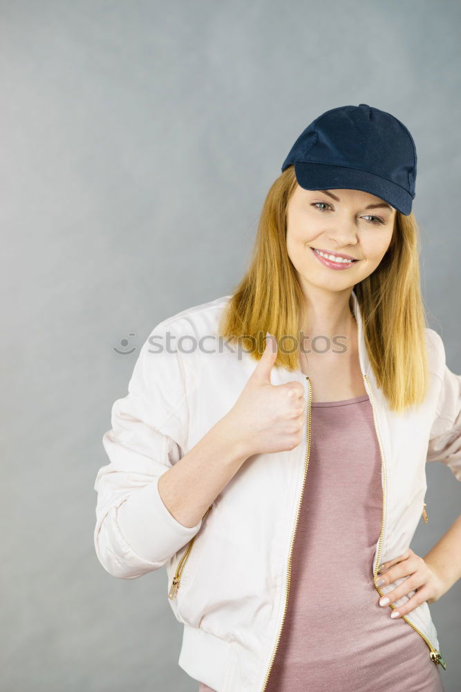 Young blonde woman smiling near a brick wall