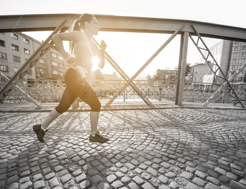 Similar – Young fitness woman runner running on city bridge.