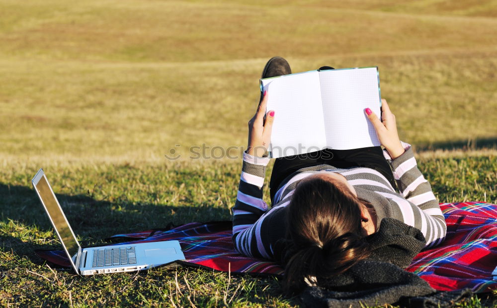 Similar – Woman reading a book outdoors