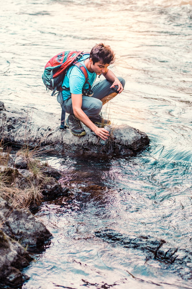 Similar – Young boy taking pure water from a river