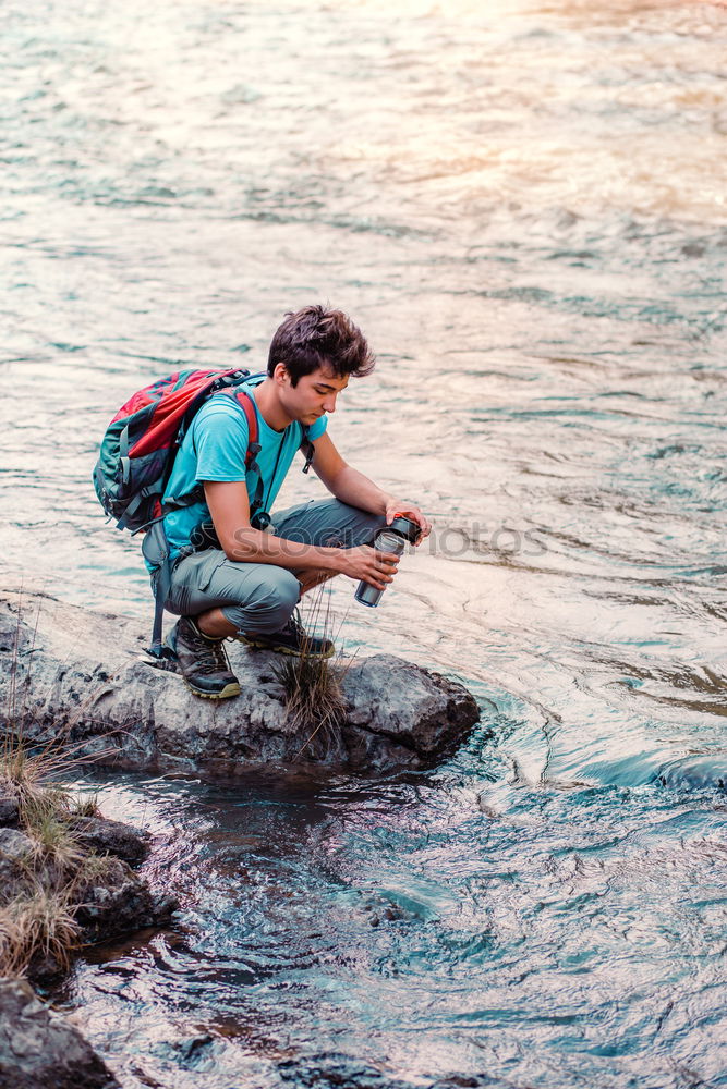 Similar – Young boy taking pure water from a river