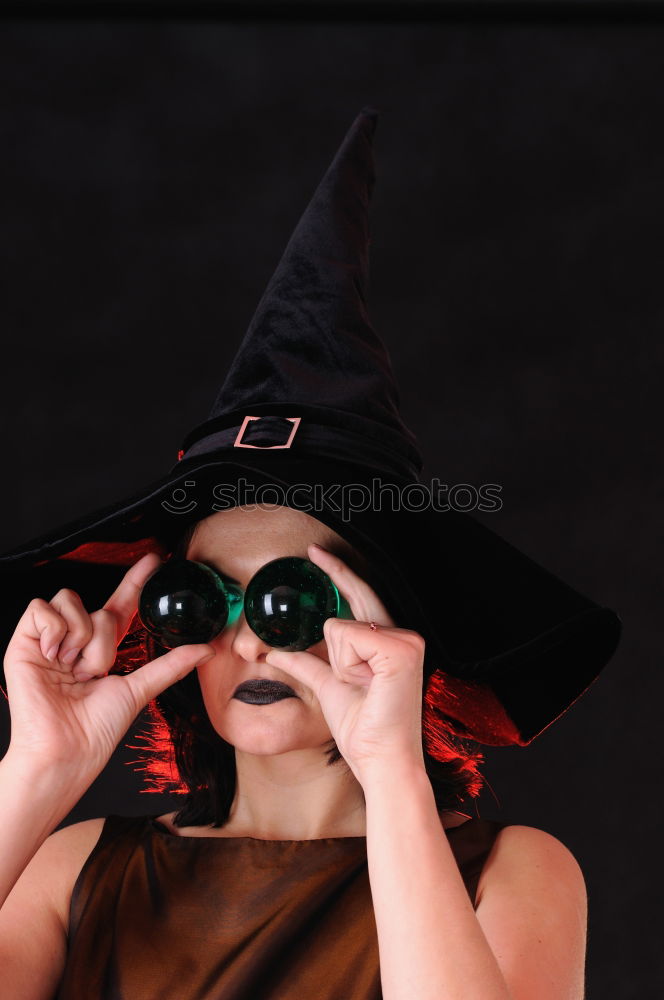 Similar – Beautiful girl disguised of witch decorating a pumpkin at home.