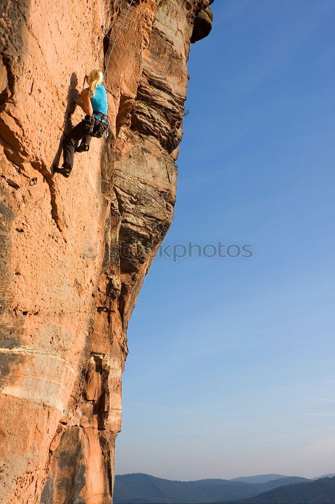 Similar – Kletterer, der sich an eine Klippe klammert.