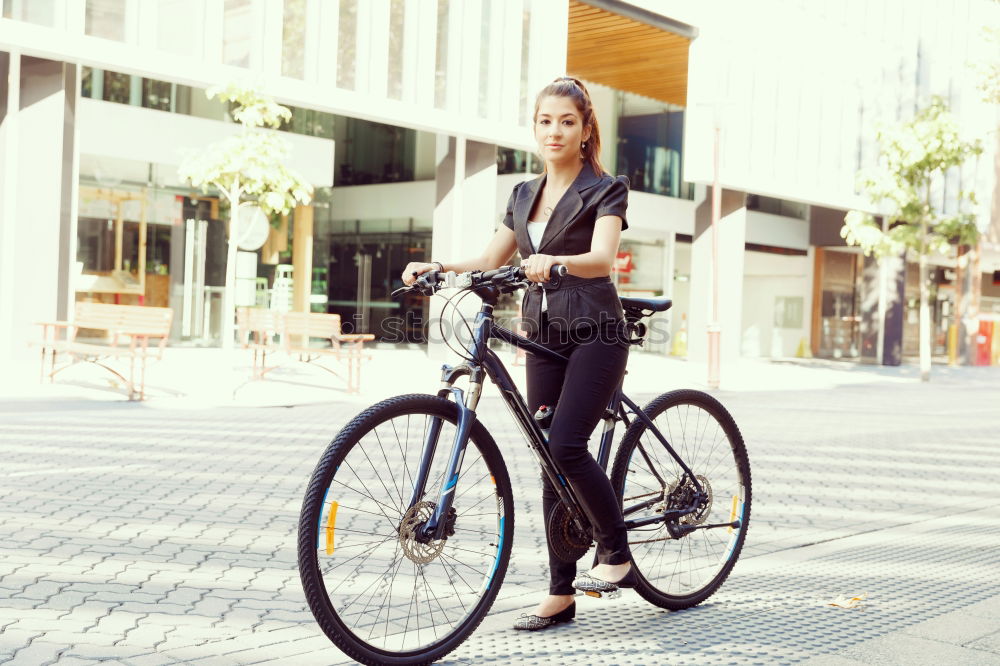 Similar – Young modern hipster riding bike trough urban city while sunset