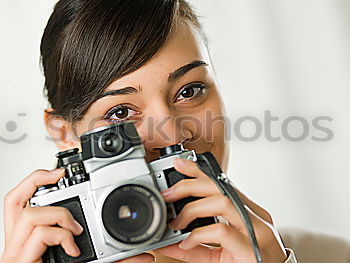 Similar – Close up of a photographer with her camera.