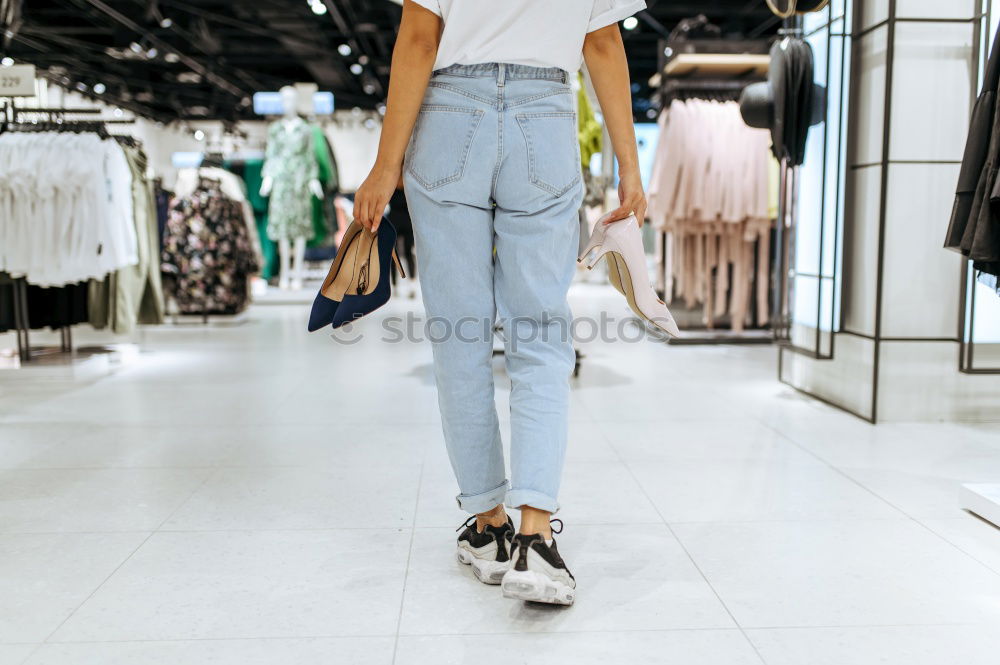 Image, Stock Photo Back view rear view of a woman holding shopping bags while wearing cool style cloths. Jeans and a top. Shopping street. Changing and buying gifts concept.