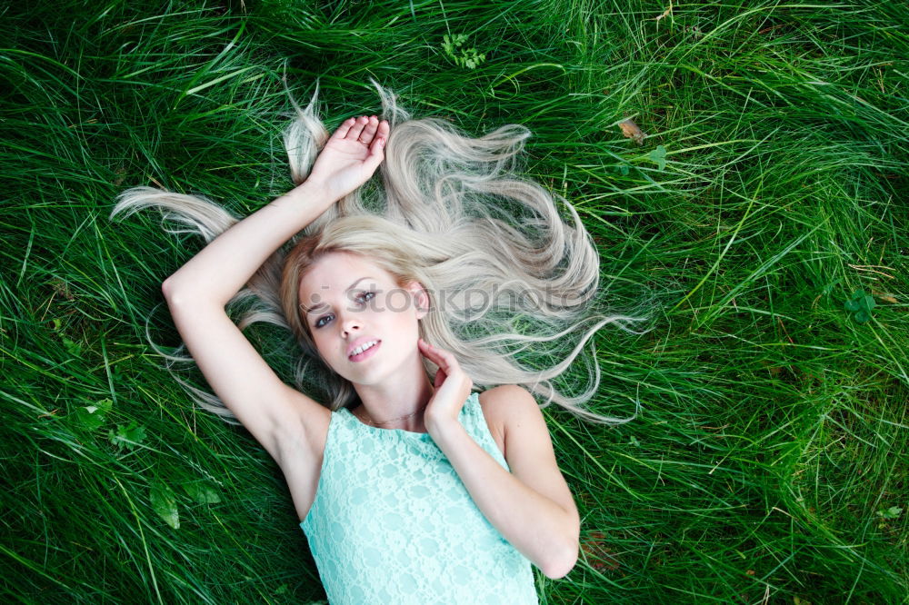 Similar – smiling portrait of a beautiful young sexy redhead woman spreading red hair fan-shaped lying relaxing on the green grass, upside down, copy space