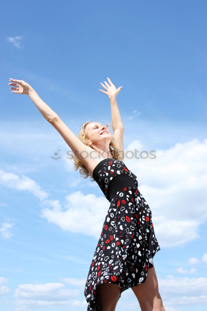 Similar – Young girl in jumpsuit with flower pattern jumps to the left in front of blue sky