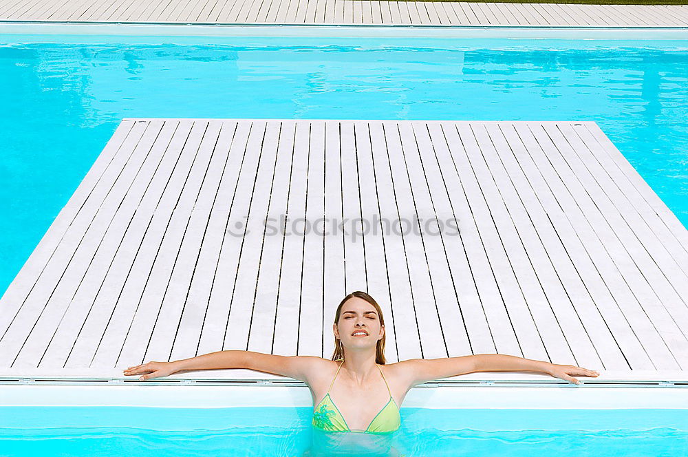 Similar – Mature brunette woman sunbathing by the pool with her feet in the water and a wrap around her body