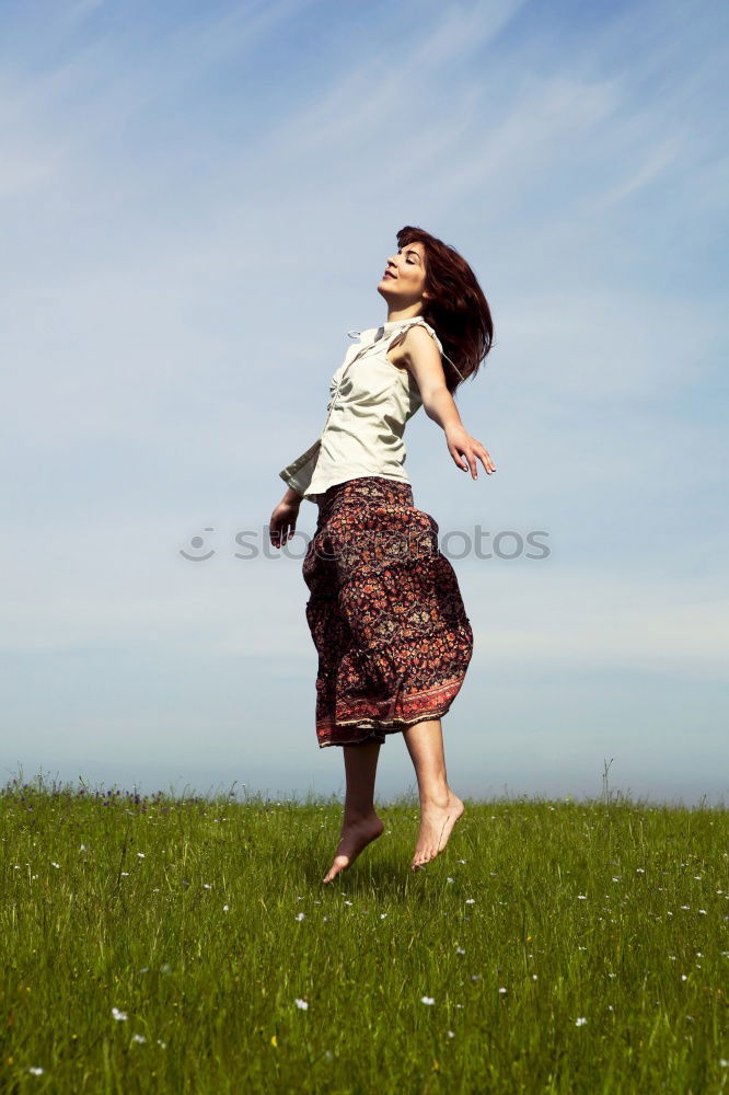 Similar – young woman jumps for joy with outstretched arms towards the sky