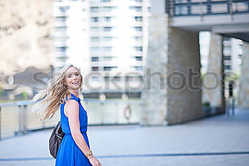 Similar – Image, Stock Photo Smiling woman in yellow dress standing and chatting on her smart phone in front of graffiti painted on corrugated iron