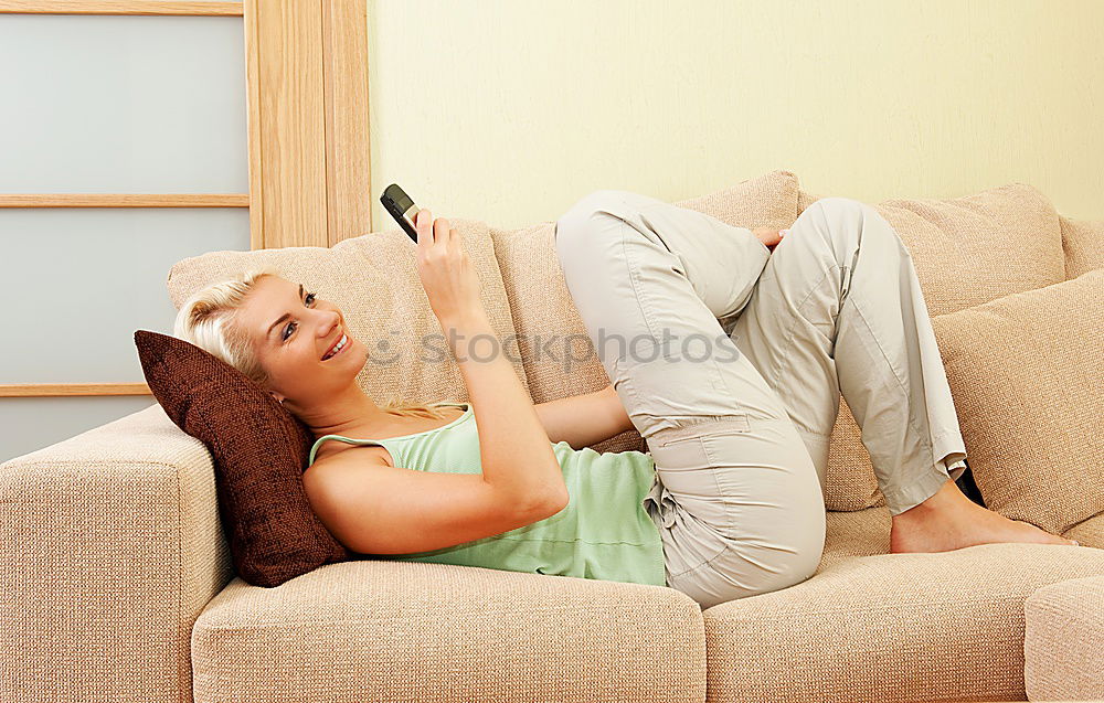 Similar – young, tall, long-legged woman stands barefoot with bare legs in front of a light sofa and looks into the camera