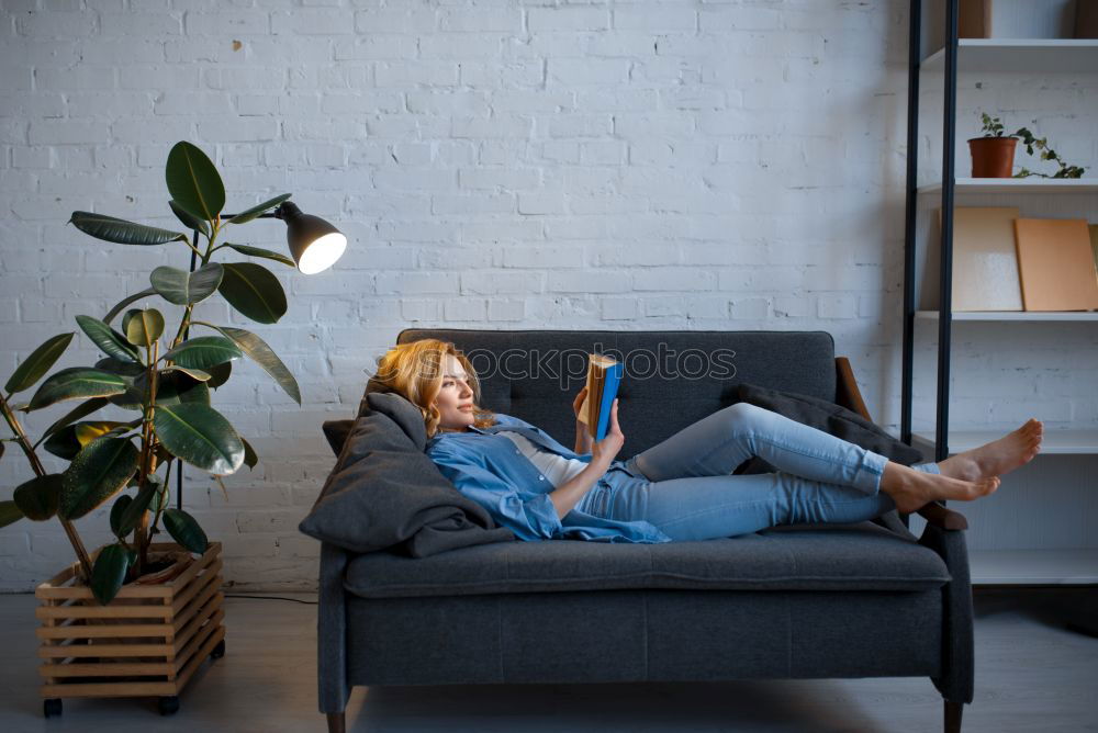 Similar – Image, Stock Photo Young woman using an smartphone and listening music while lying on a leather couch